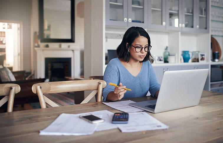 Woman adding up the various costs associated with starting a real estate career