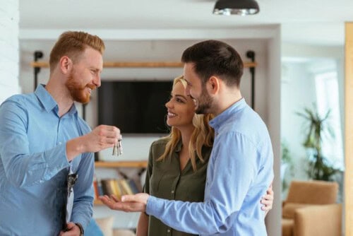 buyer’s agent gives keys to home to new owners