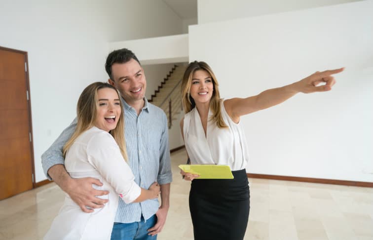 Real estate agent showing a property to a young couple