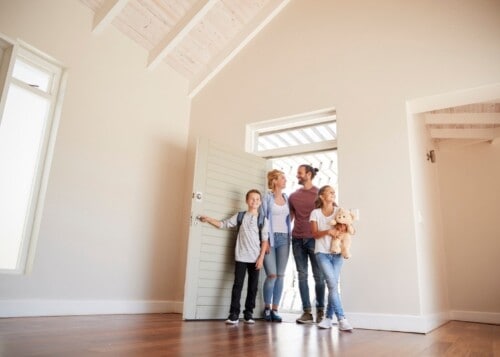 family opening door in to new home