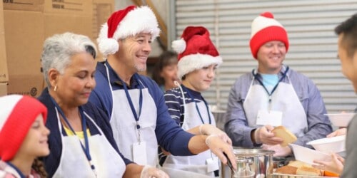 real estate agents volunteering at a food bank wearing santa hats