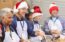 real estate agents volunteering at a food bank wearing santa hats