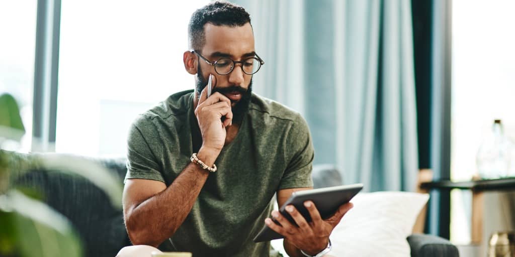 man looking at bank account on tablet