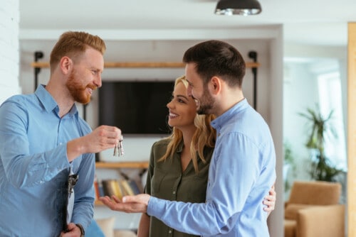 realtor handing keys to couple