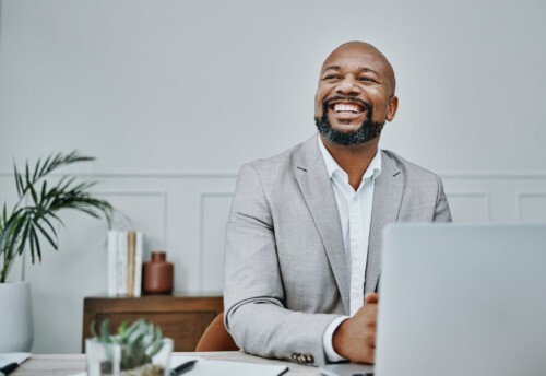 Man smiles while writing an impressive real estate bio