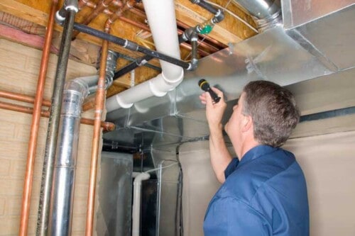 Home inspector looks at pipes