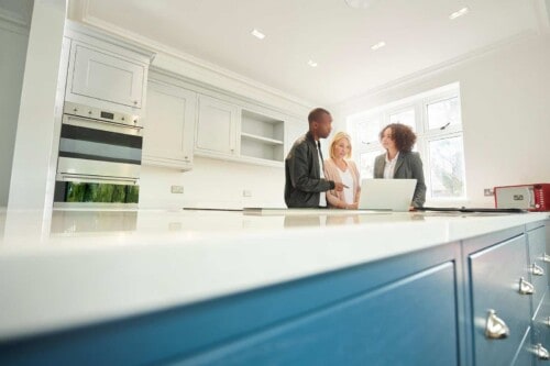 real estate agent and couple complete due diligence by inspecting kitchen