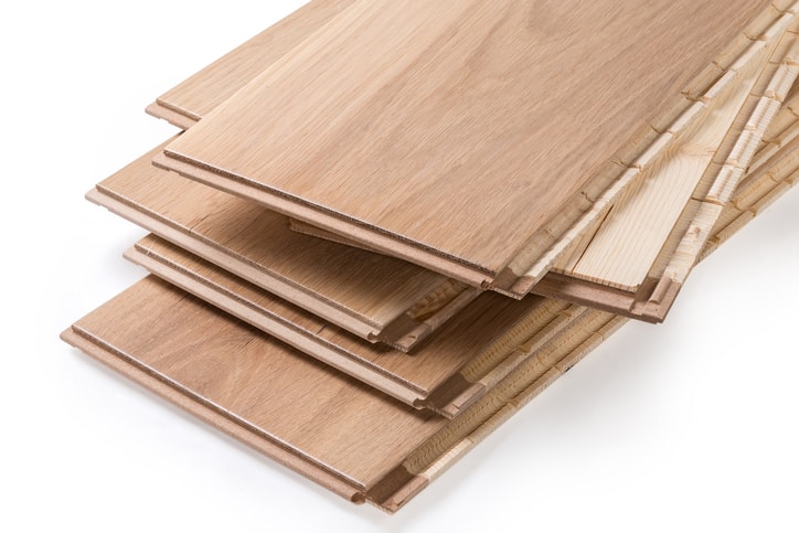 Stack of the three-layer engineered wood flooring boards with white oak face layer, pine core layer and glue-less locking joint system, fragment of butt-end parts close-up