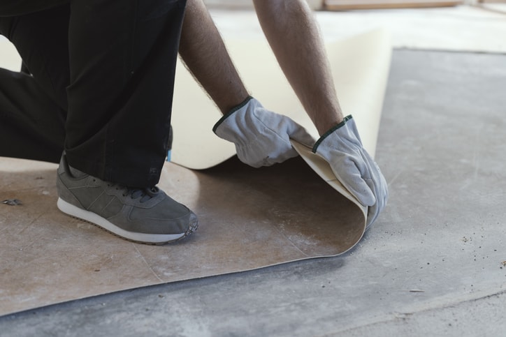 Professional contractor removing an old linoleum flooring: home renovation concept