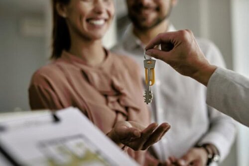 real estate agent gives keys to new homeowner