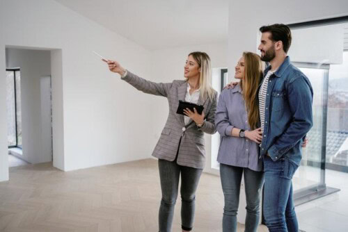 real estate agent shows home to buyers