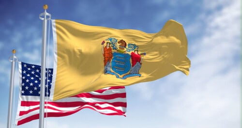 New Jersey state flag waving along with the national flag of the United States of America