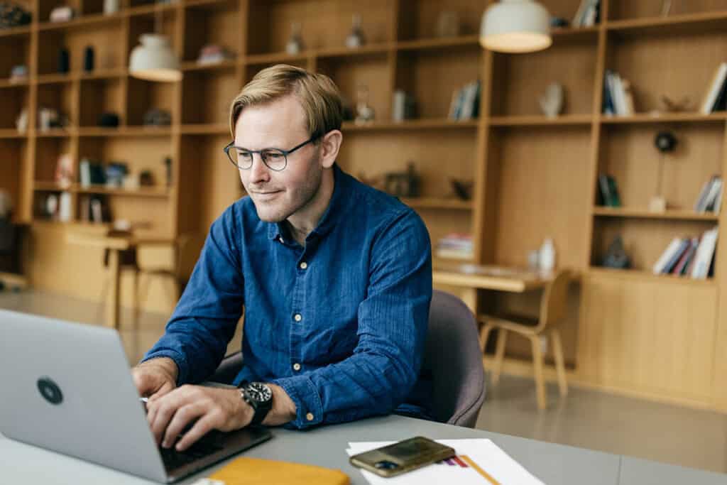 man in front of laptop studying for CE real estate exam